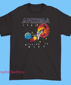 Vintage-style T-shirt featuring a graphic design of Arizona with a retro '1982 Mission to Mars' theme, including space-themed illustrations like rockets, planets, and stars, combined with bold, distressed text to evoke a nostalgic, sci-fi-inspired look.
