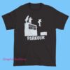 A humorous T-shirt design featuring the Dunder Mifflin logo with a playful illustration of characters performing parkour moves.